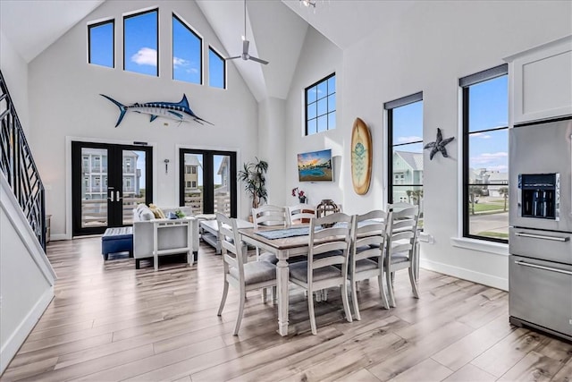 dining space featuring french doors, light wood-type flooring, baseboards, and ceiling fan