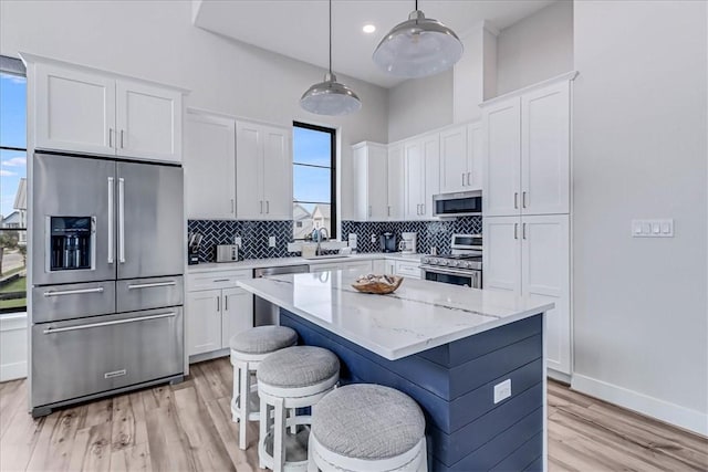 kitchen featuring decorative backsplash, a center island, a sink, and appliances with stainless steel finishes