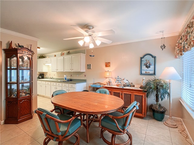 dining room featuring light tile patterned flooring, ceiling fan, sink, and crown molding