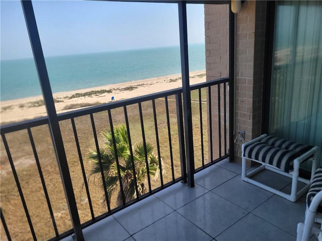 balcony with a water view and a view of the beach