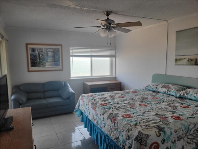 bedroom with a textured ceiling, light tile patterned flooring, a ceiling fan, and ornamental molding