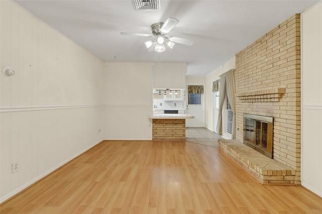 4634 Bonner Dr, Corpus Christi, TX 78411 - unfurnished living room with light wood-type flooring, a ceiling fan, and a brick fireplace