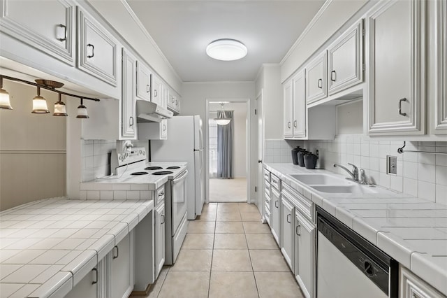 4634 Bonner Dr, Corpus Christi, TX 78411 - kitchen with white appliances, tile counters, under cabinet range hood, decorative backsplash, and crown molding