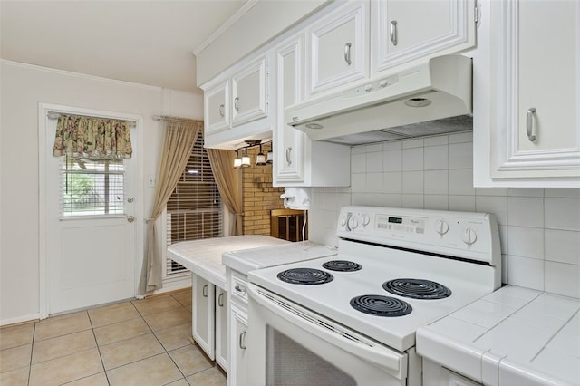 4634 Bonner Dr, Corpus Christi, TX 78411 - kitchen featuring white electric range, tile countertops, under cabinet range hood, white cabinets, and crown molding