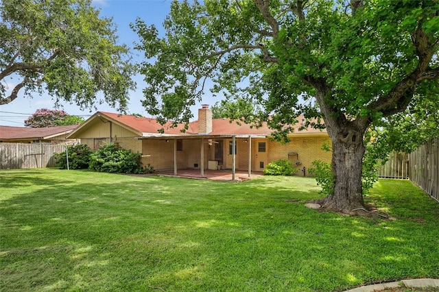 4634 Bonner Dr, Corpus Christi, TX 78411 - back of property featuring a fenced backyard, a patio area, a chimney, brick siding, and a ceiling fan