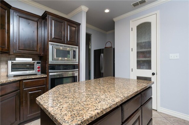 5806 Lago Vista Dr, Corpus Christi, TX 78414 - kitchen featuring stainless steel appliances, dark brown cabinets, light stone counters, baseboards, and light tile patterned floors