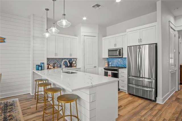 kitchen featuring white cabinetry, light wood-type flooring, appliances with stainless steel finishes, and sink