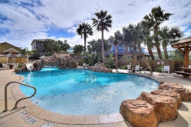 view of swimming pool featuring a water slide and a patio