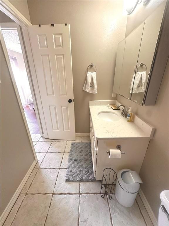 bathroom with tile patterned flooring, vanity, and toilet