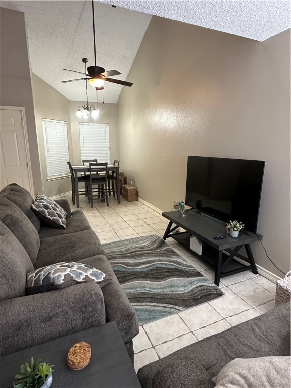 tiled living room with ceiling fan, a textured ceiling, and vaulted ceiling