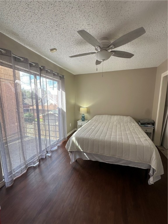 bedroom with a textured ceiling, ceiling fan, dark hardwood / wood-style floors, and access to outside