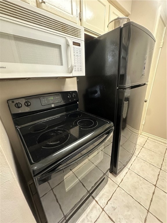 kitchen with light tile patterned floors and black appliances