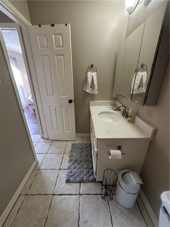 bathroom with tile patterned flooring, vanity, and toilet