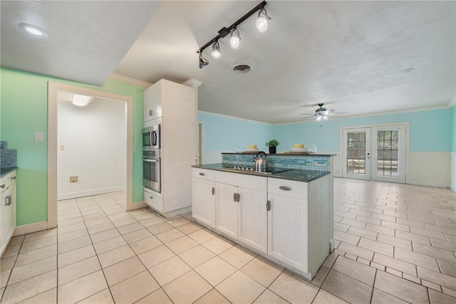 kitchen featuring light tile patterned floors, stainless steel appliances, visible vents, and white cabinets