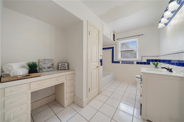 bathroom featuring toilet, a bathing tub, tile patterned flooring, vanity, and tile walls