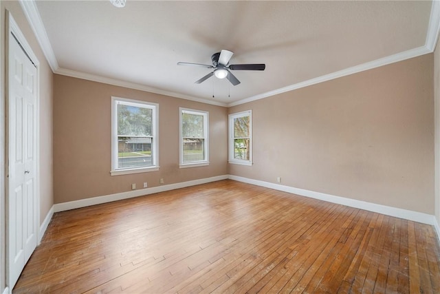 empty room featuring ceiling fan, ornamental molding, light wood-style flooring, and baseboards