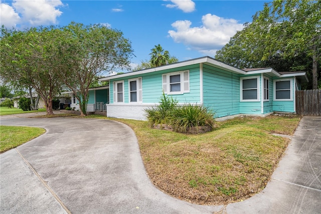 single story home with a front lawn and fence