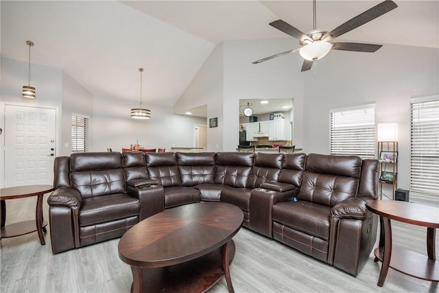 living room with ceiling fan, high vaulted ceiling, and light hardwood / wood-style floors