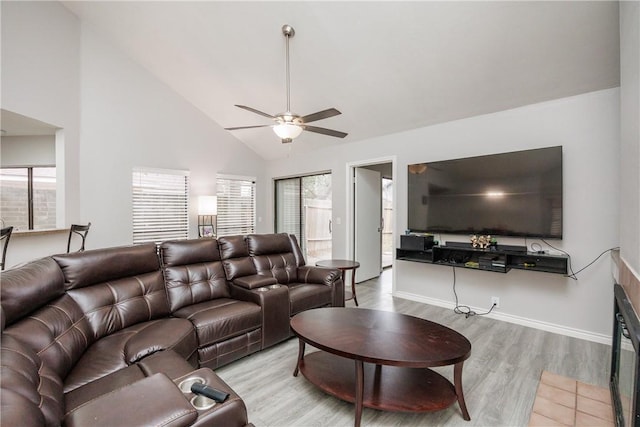 living room with ceiling fan, high vaulted ceiling, and light hardwood / wood-style flooring