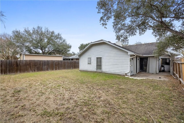 rear view of property featuring a yard and a patio area