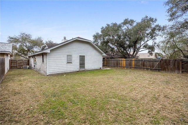 rear view of house featuring a lawn and central air condition unit