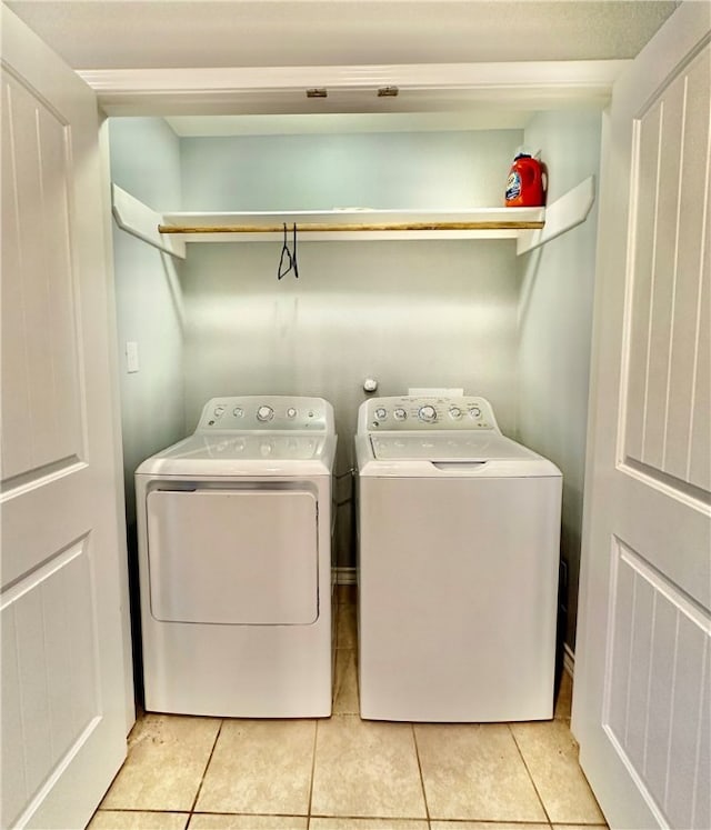 laundry area featuring washer and dryer and light tile patterned floors