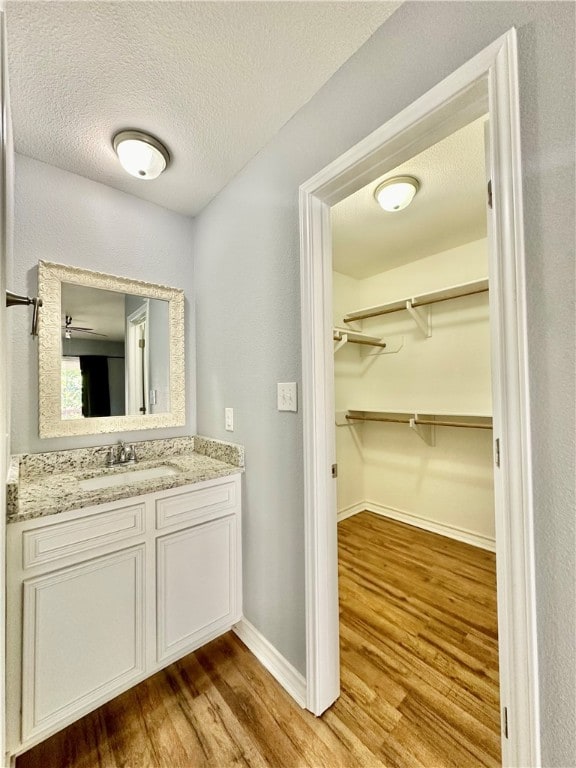 bathroom featuring hardwood / wood-style floors, vanity, and a textured ceiling