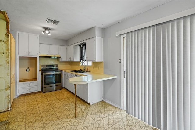 5725 Woodhaven Dr, Corpus Christi, TX 78412 - kitchen featuring electric range, under cabinet range hood, light countertops, and white cabinetry