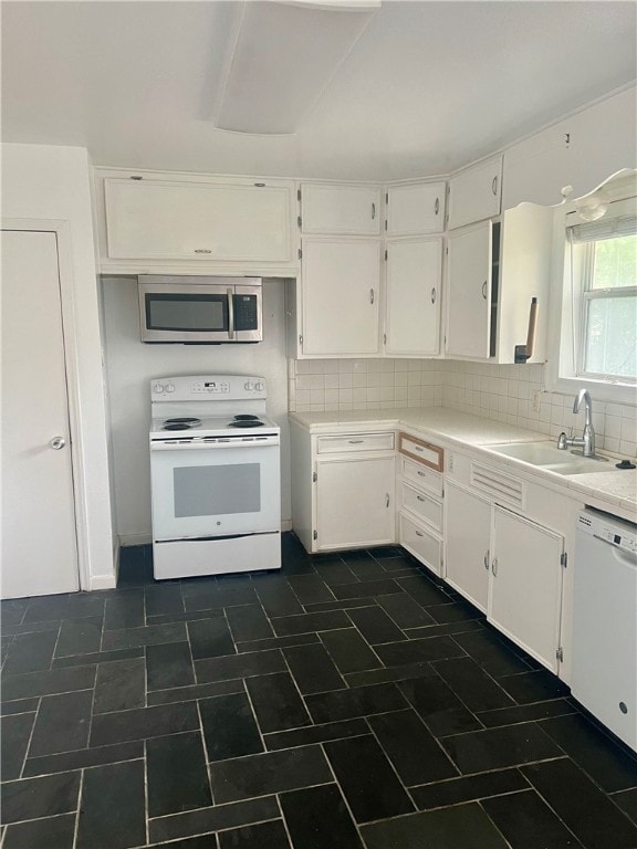 kitchen with white appliances, white cabinetry, sink, and decorative backsplash