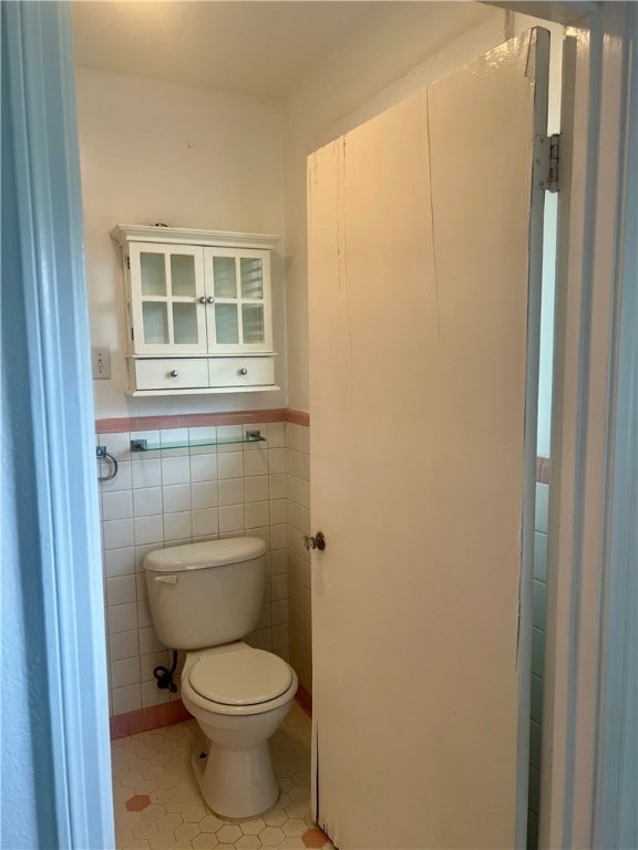 bathroom with tile walls, tile patterned flooring, and toilet