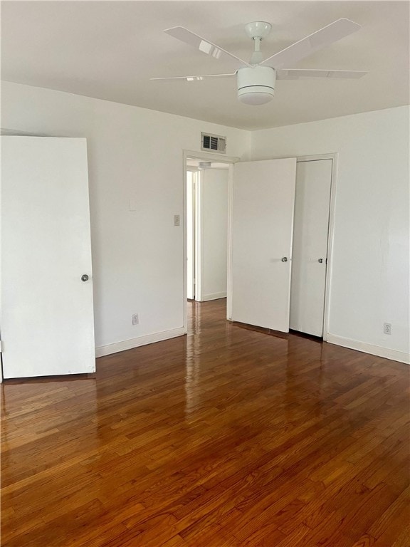 spare room featuring dark hardwood / wood-style flooring and ceiling fan