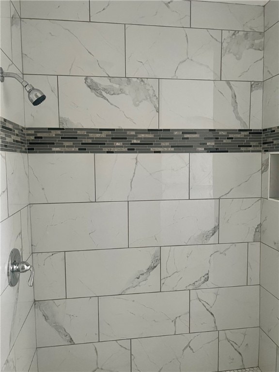 interior details with a tile shower