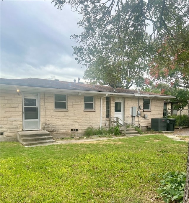 rear view of house with a lawn and cooling unit