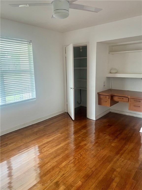 unfurnished bedroom featuring hardwood / wood-style flooring, a closet, and built in desk