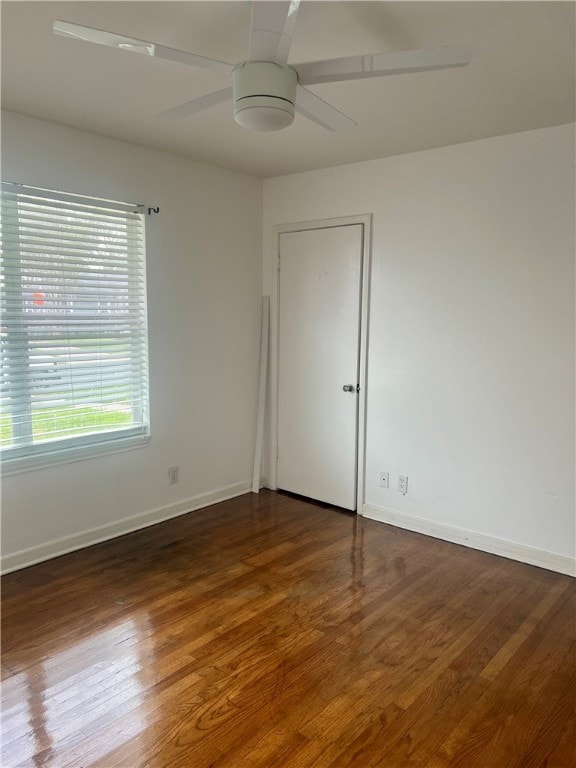 empty room with dark wood-type flooring and ceiling fan