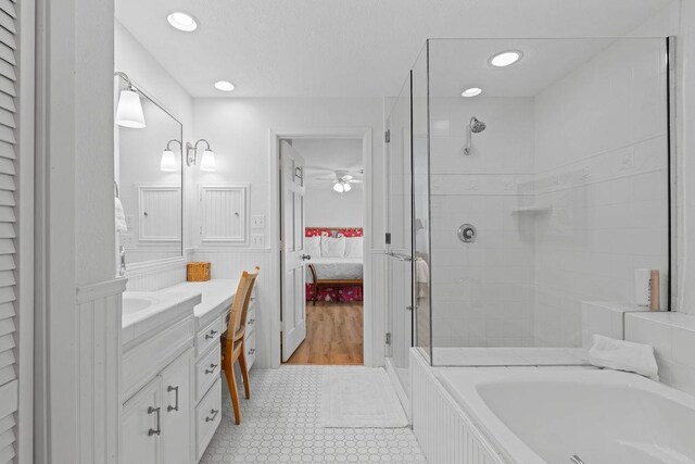 13 Sandpiper Ln, Rockport, TX 78382 - ensuite bathroom featuring vanity, a shower stall, a bath, a wainscoted wall, and recessed lighting
