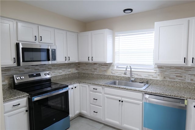 3022 Chapel Creek Dr, Corpus Christi, TX 78414 - kitchen featuring appliances with stainless steel finishes, tasteful backsplash, white cabinetry, and light stone countertops