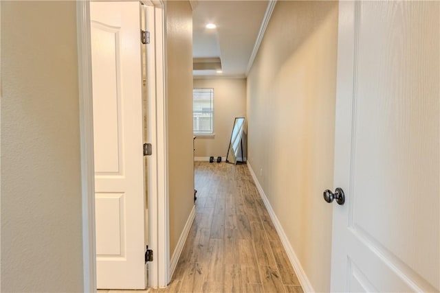 corridor featuring crown molding, recessed lighting, baseboards, and light wood-type flooring