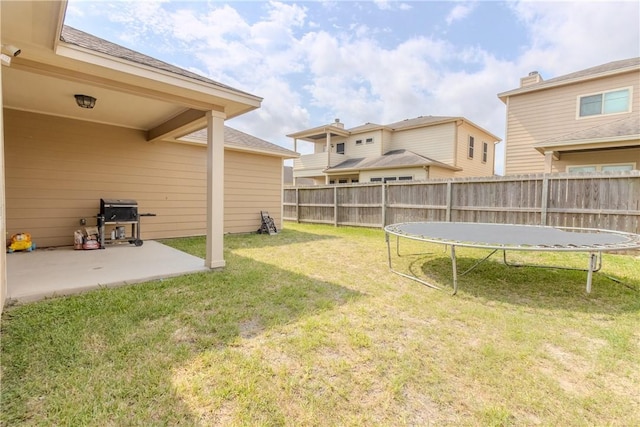 view of yard featuring a patio, a fenced backyard, and a trampoline