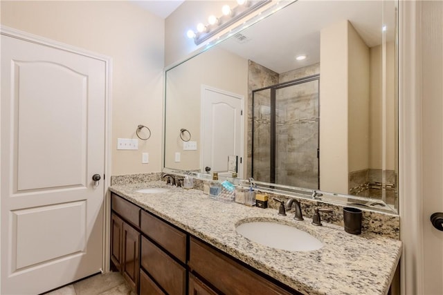 bathroom with double vanity, a shower stall, and a sink