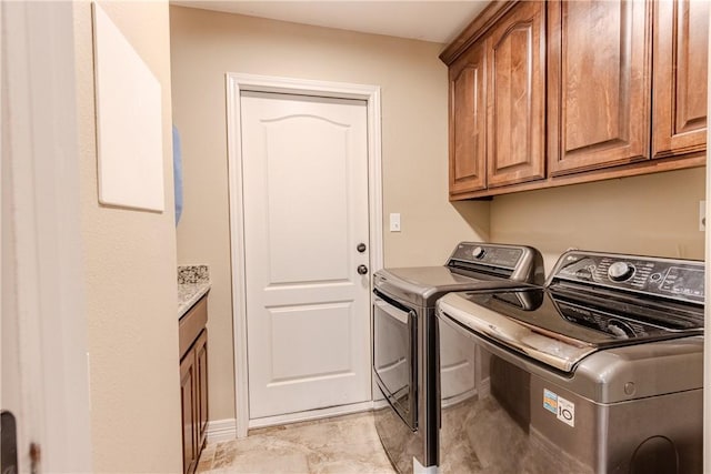 laundry area with separate washer and dryer and cabinet space