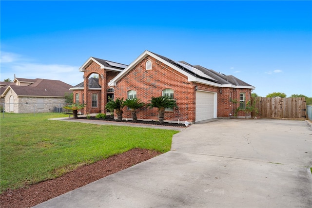 view of front of home featuring a garage, solar panels, and a front yard