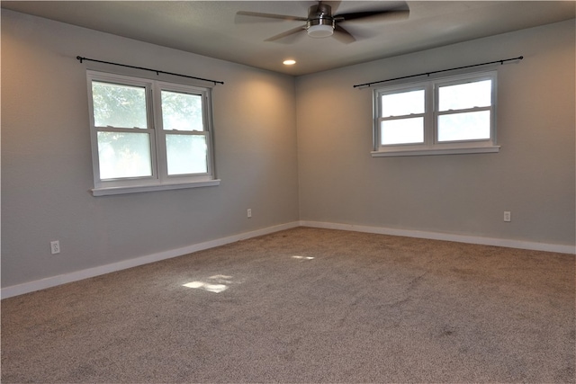 carpeted spare room featuring ceiling fan