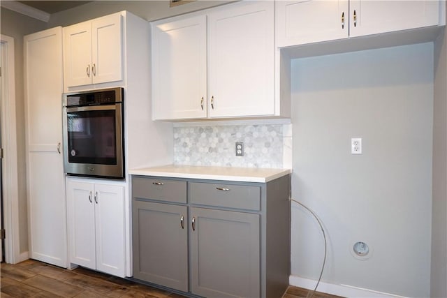 kitchen with gray cabinetry, white cabinets, oven, decorative backsplash, and dark hardwood / wood-style flooring