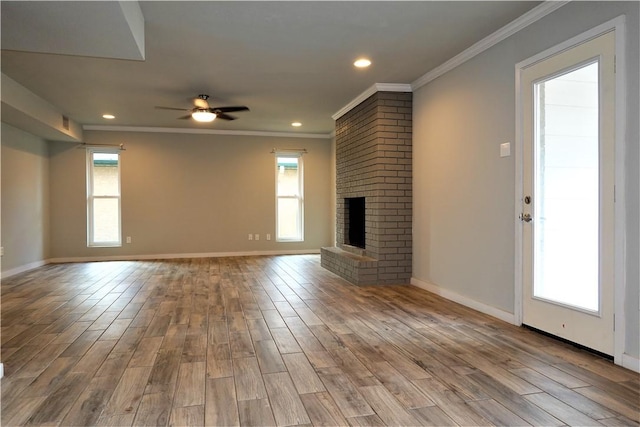 unfurnished living room with a brick fireplace, light hardwood / wood-style flooring, a wealth of natural light, and ceiling fan