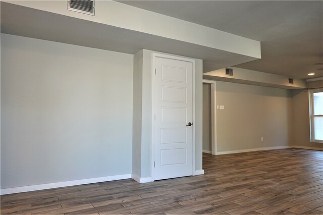 basement with dark hardwood / wood-style floors