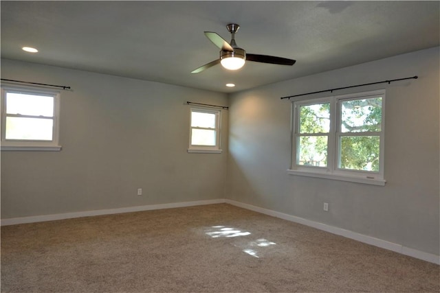 carpeted spare room with ceiling fan