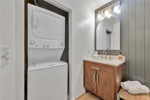 laundry room with stacked washer and dryer and sink