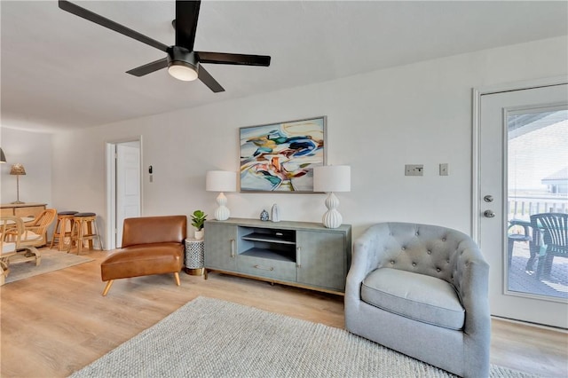 living room featuring ceiling fan and light hardwood / wood-style flooring