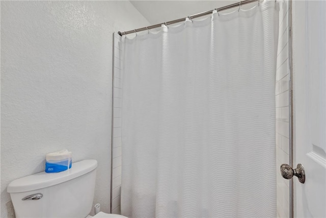 bathroom featuring a shower with shower curtain and toilet